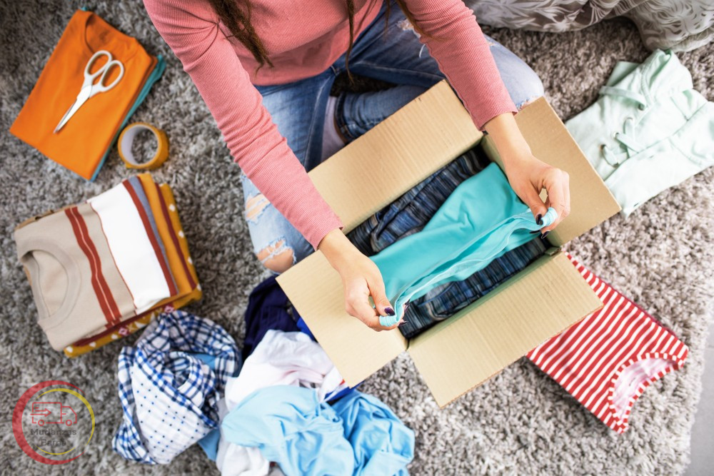 Empaquetar ropa en una caja de mudanza